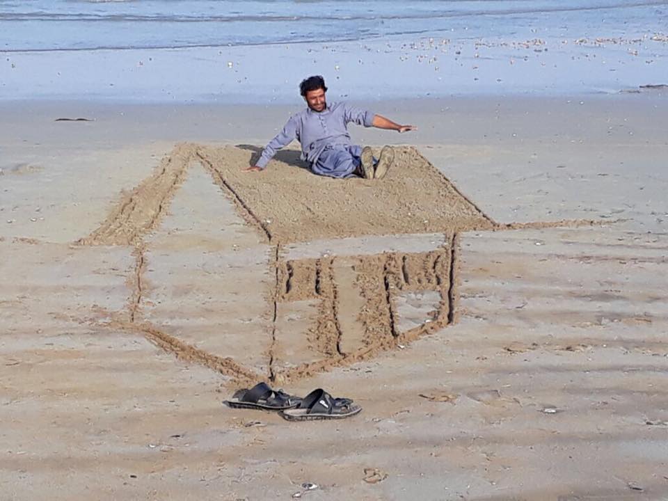 Artist enjoying in sun on his new hand drawn hut roof